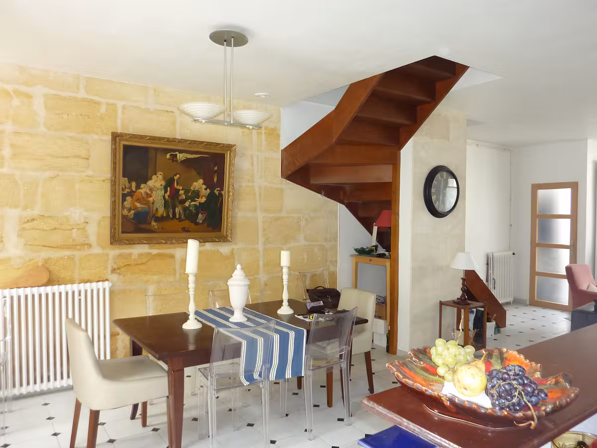 Le séjour, son mur en pierre de Bordeaux et son escalier en colimaçon